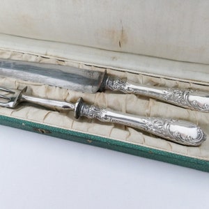 May include: A silver carving set with an ornate handle design, in a green velvet lined box.