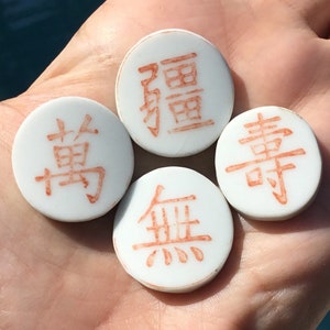 May include: Four white ceramic tiles with red Chinese characters. The characters are "無", "書", "場", and "翻".