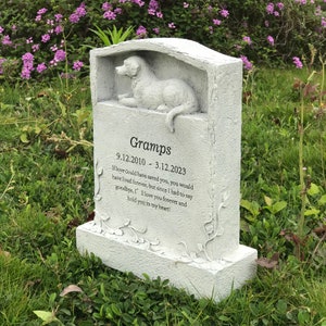 May include: A white stone pet memorial with a carved dog sculpture. The inscription reads "Gramps 9.12.2010 - 3.12.2023" and includes a poem about love and remembrance.