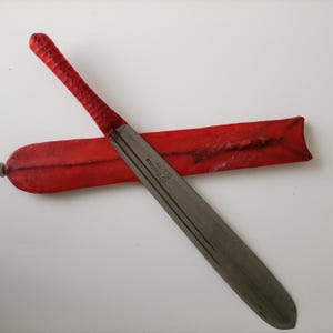 May include: A silver blade with a red leather handle and sheath. The blade is marked "Klingenthal  Made in Germany".