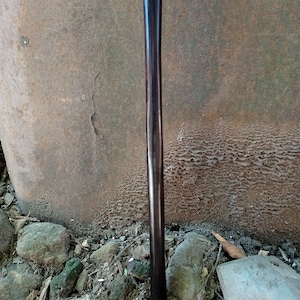 May include: A dark brown wooden walking stick with a smooth, polished finish.