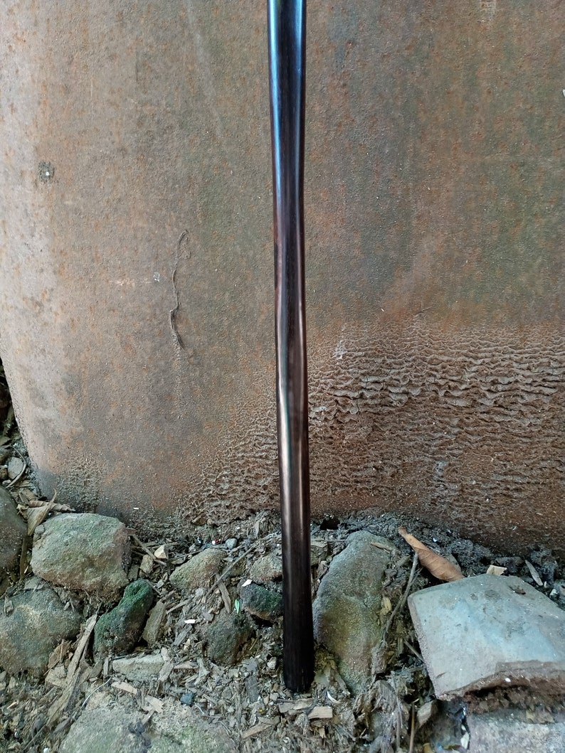May include: A dark brown wooden walking stick with a smooth, polished finish.