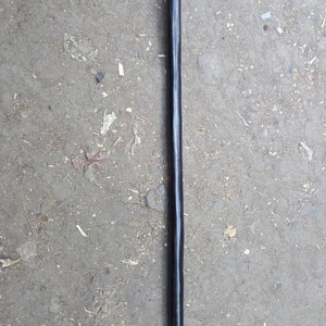May include: A black wooden walking stick with a curved handle.