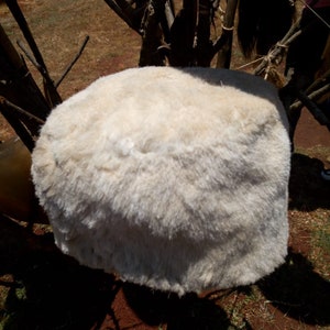 May include: A white fluffy round hat made of fur.