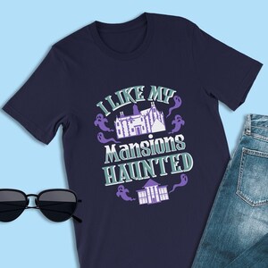 May include: A navy blue t-shirt with a graphic of a haunted mansion and the text "I like my mansions haunted".