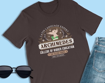 May include: A brown t-shirt with a graphic design of a cartoon owl holding a book. The graphic includes the text "Latin Language Expert", "Archimedes", "College of Higher Education", "The Tilting Tower", and "Since 17th Century".