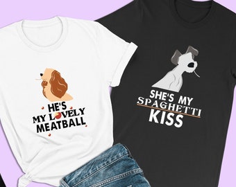 Puede incluir: Dos camisetas blancas con un perro de dibujos animados en cada una. La camiseta blanca de la izquierda tiene un perro marrón y blanco con el texto "He's my lovely meatball." La camiseta blanca de la derecha tiene un perro blanco con el texto "She's my spaghetti kiss."