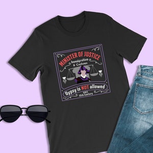 May include: Black t-shirt with a vintage-style graphic of a judge with a scale and the text "Minister of Justice Immigration & Customs Gypsy is NOT allowed since 15th Century".