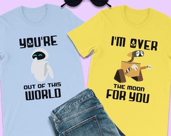 May include: Two t-shirts with a light blue and yellow background. The shirts feature a cartoon robot from the movie Wall-E. The text on the shirts reads "You're out of this world" and "I'm over the moon for you".