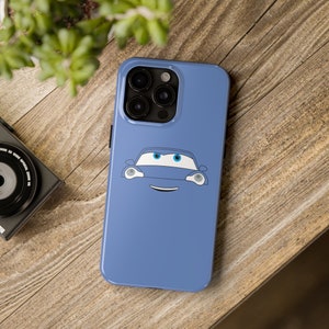 May include: A blue phone case with a cartoon car face on it. The car has blue eyes and a white smile.