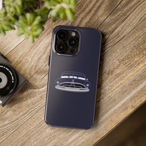 Puede incluir: Una funda de teléfono azul oscuro con una imagen de dibujos animados en blanco y negro de un coche antiguo con ojos azules. La funda del teléfono tiene un recorte para el objetivo de la cámara con cuatro círculos negros.