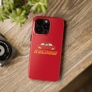 May include: Red phone case with a cartoon image of a red race car with the word "KACHOW" printed below it.