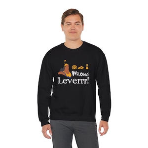 Puede incluir: Sudadera negra con una imagen de dibujos animados de un hombre con una corona y el texto "Wrong Leverrr!" impreso en la parte delantera.