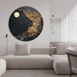 May include: A circular abstract painting with a textured black background and gold accents. The painting features a large, round, gold shape in the center, resembling a sun or moon.