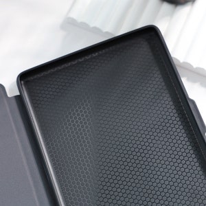 May include: Black case with a honeycomb pattern on the inside. The case is made of a soft material and has a smooth, matte finish.