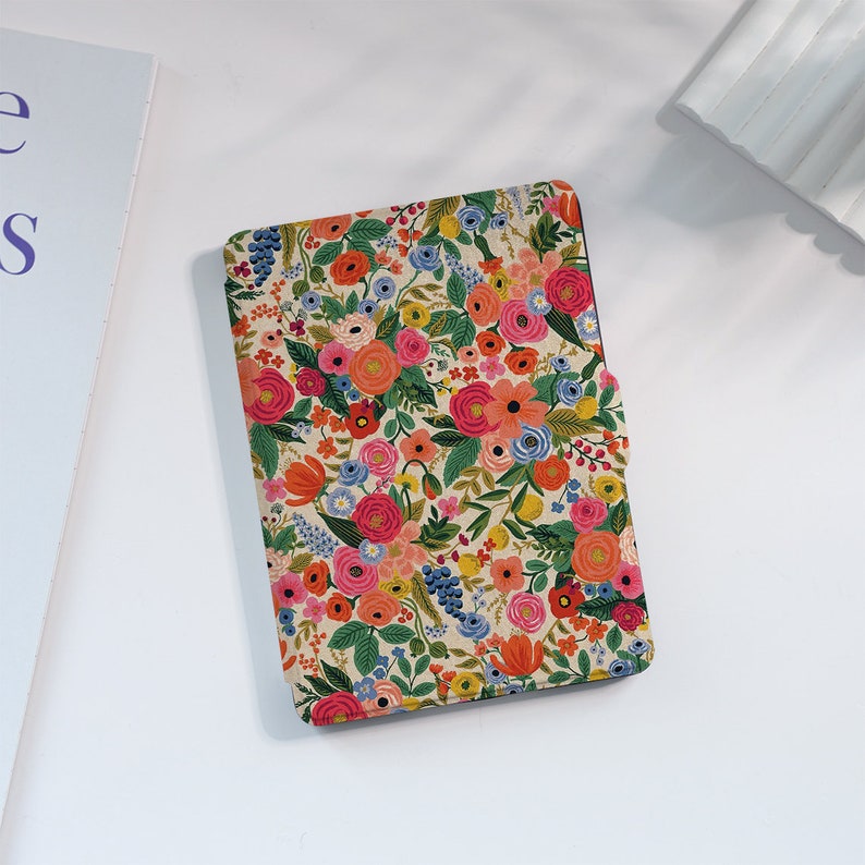 May include: A floral patterned e-reader cover with a cream background and colorful flowers, including pink, red, orange, yellow, blue, and green.