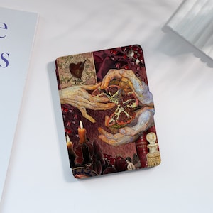 May include: A collage of images featuring a heart, hands, a pomegranate, candles, and a book with the text "Scottish Poets". The background is a dark red fabric.