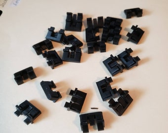 May include: A collection of twenty-two black plastic clips. The clips are all the same size and shape, and they have a simple, functional design.