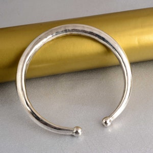 Peut inclure: Un bracelet en argent avec des extrémités arrondies. Le bracelet est lisse et brillant.