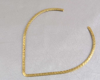 May include: A gold-toned hammered metal choker necklace. The necklace is a simple, open circle shape.