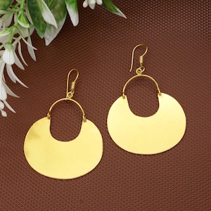 Puede incluir: Un par de pendientes de color dorado con forma de media luna. Los pendientes están hechos de metal y tienen un diseño simple y elegante.
