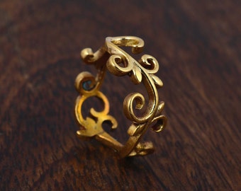 May include: A gold filigree ring with a delicate floral design. The ring is made of metal and has a smooth finish.