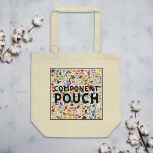 Könnte beinhalten: Eine beige Tragetasche mit einem schwarzen quadratischen Design, das ein farbenfrohes Muster aus verschiedenen kleinen Objekten und dem Text "COMPONENT POUCH" zeigt.