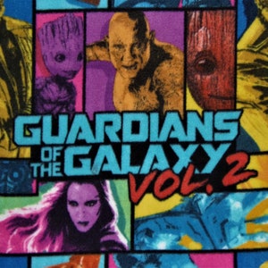 May include: A colorful fabric with a repeating pattern of characters from the movie Guardians of the Galaxy Vol. 2. The fabric features images of Rocket Raccoon, Groot, Drax, Gamora, and Star-Lord. The title "Guardians of the Galaxy Vol. 2" is printed in large, bold letters.