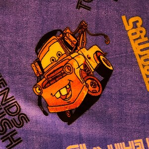 May include: A purple blanket with a cartoon image of a yellow tow truck with a smiling face. The text "FRIENDS FINISH" is printed in black on the blanket. The text "Salvation" is printed in yellow on the blanket.