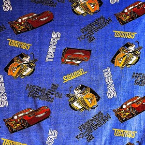 May include: Blue fleece blanket with a Cars theme. The blanket features images of Lightning McQueen and Mater, along with the text "Friends to the Finish" and "Team 95".