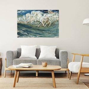 May include: A painting of white horses running through the ocean waves. The water is a deep blue and green, and the horses are white with foamy crests. The painting is framed and hanging on a white wall.