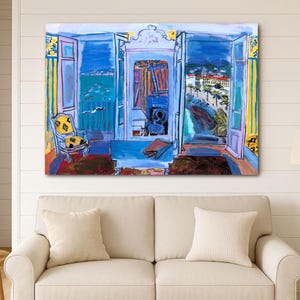 May include: A vibrant painting depicts an open doorway overlooking a coastal scene. The artwork features a blue and white color palette, with a view of the sea, buildings, and palm trees. A yellow patterned chair is visible in the foreground.