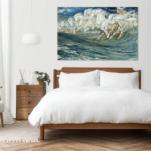 May include: A painting of white horses running through the ocean waves. The painting is in a modern bedroom setting above a bed with white bedding.