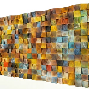 May include: A wall art piece made of wood with a variety of colors and textures. The wood is arranged in a geometric pattern, creating a unique and modern look.