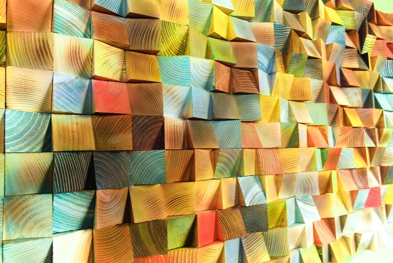 May include: A wall art piece made of colorful wooden blocks arranged in a geometric pattern. The blocks are stained in shades of blue, green, yellow, orange, and red.