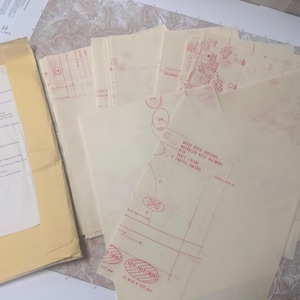 May include: A collection of vintage military maps and documents. The maps are printed in red ink on translucent paper, with detailed diagrams and text. A manila envelope with a document is on the left. The documents appear to be from the U.S. Department of the Army.