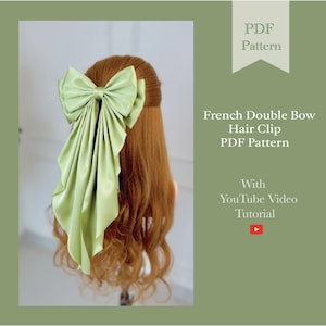 May include: A light green satin French double bow hair clip. The bow is large and has long, flowing tails. The image also includes text that reads "PDF Pattern" and "French Double Bow Hair Clip PDF Pattern With YouTube Video Tutorial."
