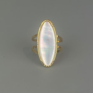 Adjustable stainless steel ring. Gold ring with a large oval mother-of-pearl stone. Jewelry for a gift.