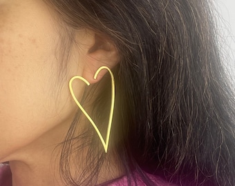 Heart-shaped hoop earrings in stainless steel. Gold hoop earrings in stainless steel. Heart earrings. Modern gold earrings.