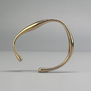 Gold bracelet organic shape in stainless steel. Irregular gold bangle. Original shape bracelet in steel.