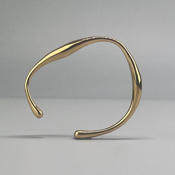 Organisch geformtes Goldarmband aus Edelstahl. Unregelmäßiger Goldarmreif. Originell geformtes Armband aus Stahl.