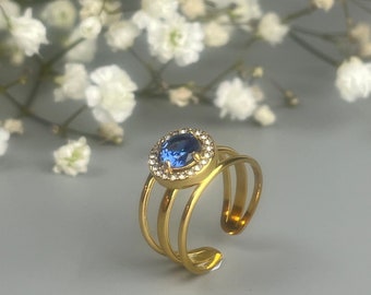 Bague or en acier inoxydable avec une pierre couleur bleu de Londres. Bague de fiançailles or avec un zircon bleu cerclé de diamant.
