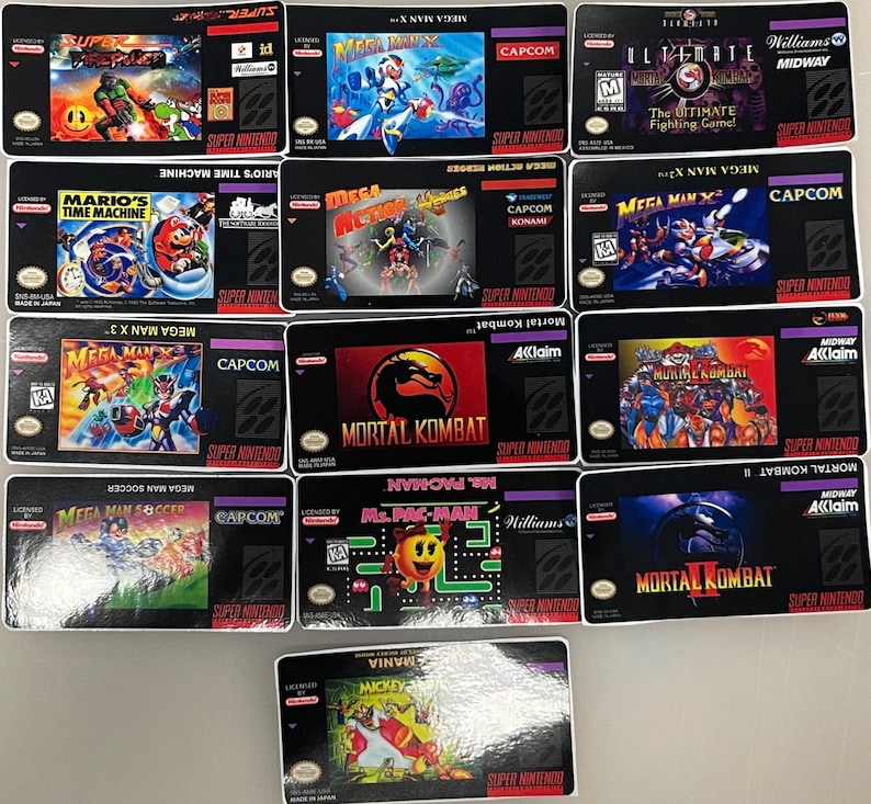 K&ouml;nnte beinhalten: Eine Sammlung von Super Nintendo-Spielkassetten mit Titeln wie "Mortal Kombat", "Mega Man X" und "Mario's Time Machine". Die Kassetten zeigen farbenfrohe Spielgrafiken und Logos mit schwarzen Hintergr&uuml;nden und lila R&auml;ndern. Spiele von verschiedenen Herausgebern.