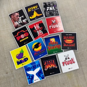 K&ouml;nnte beinhalten: Eine Sammlung von 12 bunten Aufklebern mit verschiedenen Designs, darunter eine Banane, ein Videospielcharakter, ein Wal und ein Basketballspieler. Die Aufkleber sind alle quadratisch und haben einen wei&szlig;en Rand. Der Text auf den Aufklebern lautet "Drift King", "Nuclear Heat", "Life of the Party", "Bang!" und "Rival".