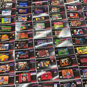 K&ouml;nnte beinhalten: Eine Sammlung von Super Nintendo Entertainment System (SNES) Spielkassetten. Die Kassetten zeigen farbenfrohe Spielbox-Artworks und Titel wie "Kirby Super Star", "Earthbound" und "Final Fight". Die Spiele sind eng angeordnet.