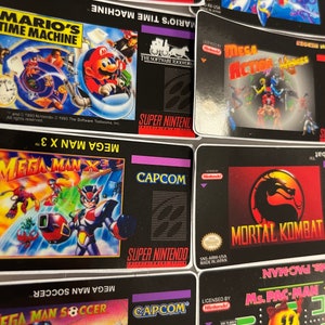 K&ouml;nnte beinhalten: Eine Sammlung von Super Nintendo-Spielkassetten, darunter "Mario's Time Machine", "Mega Man X3" und "Mortal Kombat". Die Kassetten haben schwarze Hintergr&uuml;nde mit farbenfrohen Spielgrafiken und dem Super Nintendo-Logo.