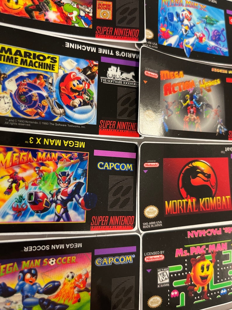 K&ouml;nnte beinhalten: Eine Sammlung von Super Nintendo-Spielkassetten, darunter "Mario's Time Machine", "Mega Man X3" und "Mortal Kombat". Die Kassetten haben schwarze Hintergr&uuml;nde mit farbenfrohen Spielgrafiken und dem Super Nintendo-Logo.