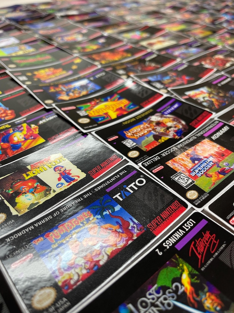 K&ouml;nnte beinhalten: Nahaufnahme einer Sammlung von Super Nintendo-Spielmodulen. Die Boxen zeigen farbenfrohe Kunstwerke von Spielen wie "The Flintstones: The Treasure of Sierra Madrock" und "Harvest Moon". Die Module sind eng aneinandergereiht.