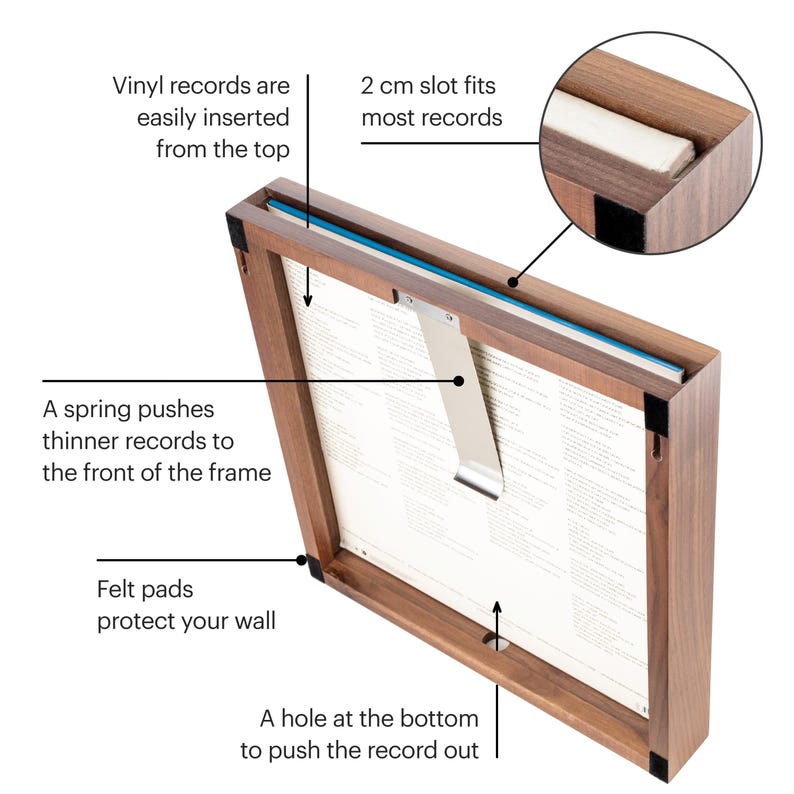 Op de afbeelding: Een houten frame met een veermechanisme om vinylplaten vast te houden. Het frame heeft een gleuf van 2 cm om de meeste platen te passen en een gat aan de onderkant om de plaat eruit te duwen. Viltpads beschermen de muur.