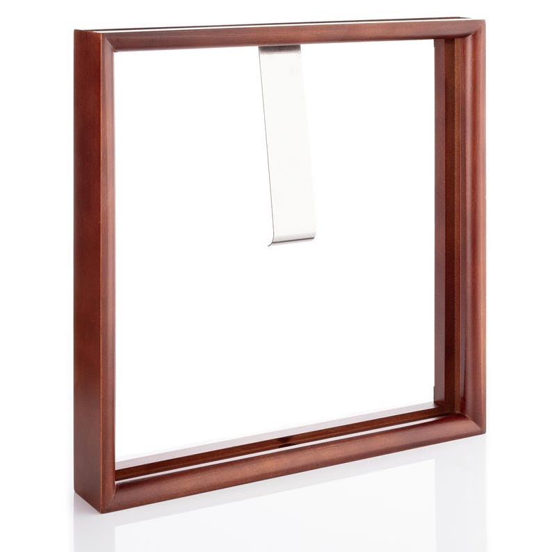 Op de afbeelding: Een donkerbruin houten fotolijst met een zilveren ophangclip. De lijst is leeg en klaar om een foto of kunstwerk te tonen.